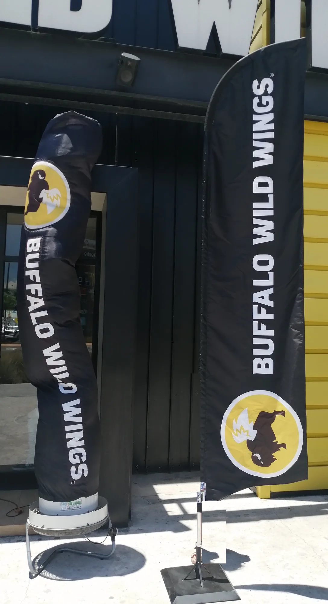 Sky Dancer y bandera Buffalo Wild Wings frente a una sucursal